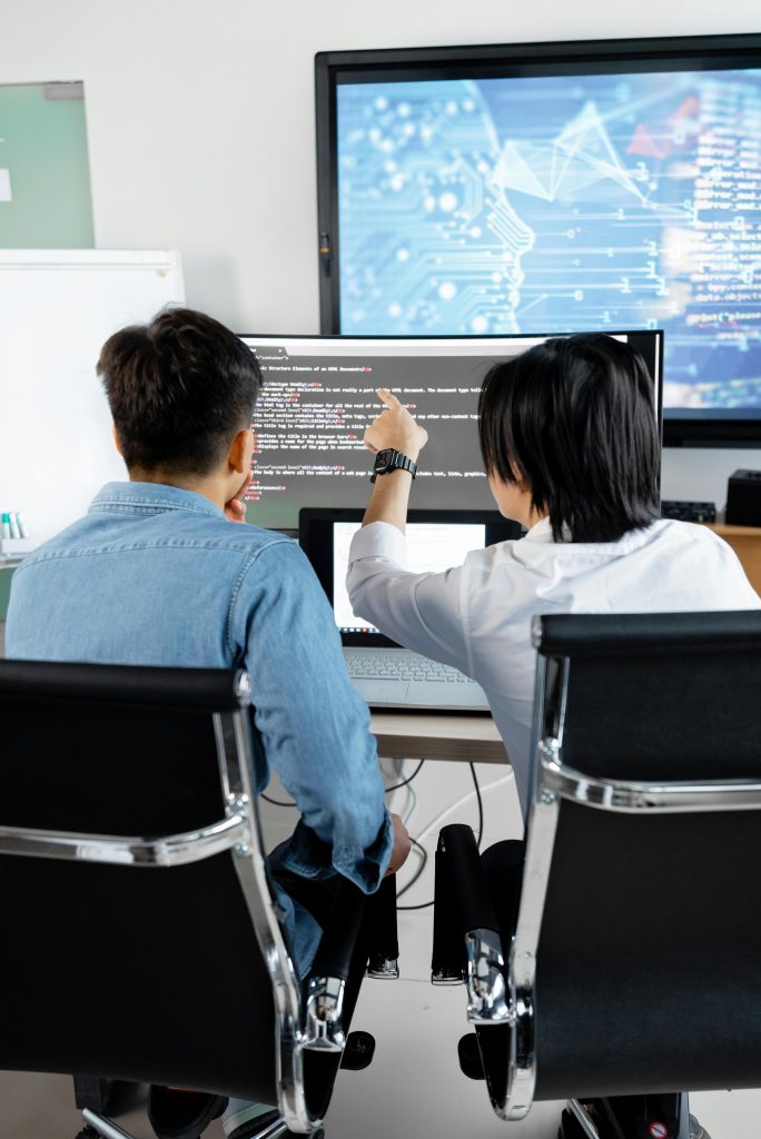 pexels-mikhail-nilov-7988759 Zwei IT-Fachkräfte analysieren Code am Monitor